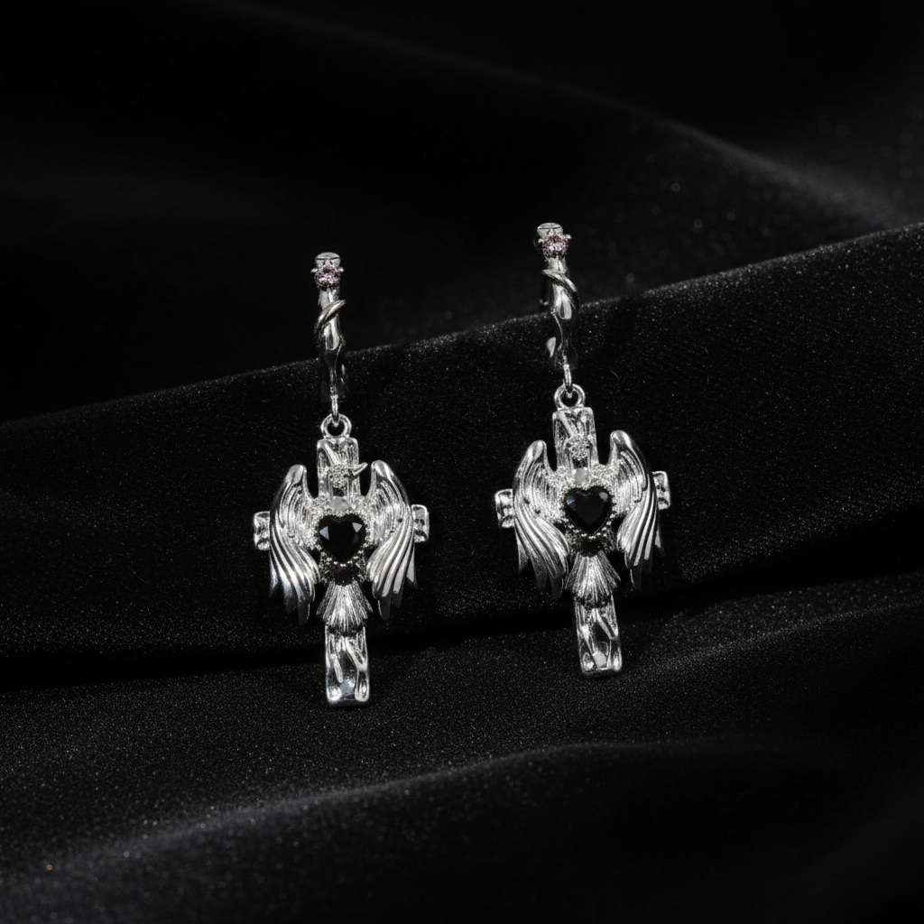 Pair of silver cross earrings with black stones on a dark background